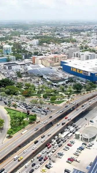 Vista aérea de la avenida John F. Kennedy en el borde sur de Arroyo Hondo Viejo, Santo Domingo, con la tienda IKEA y el sector al fondo