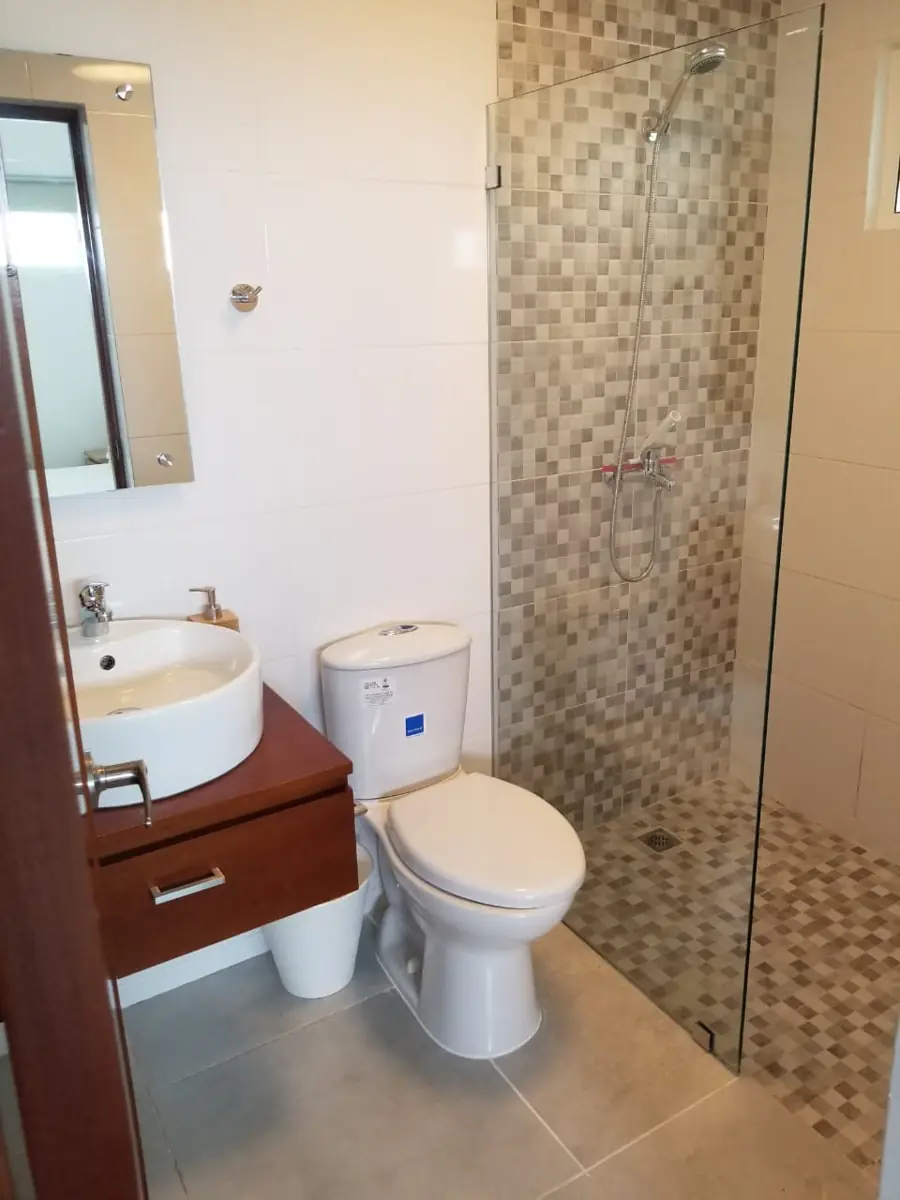Baño con ducha de cristal y mueble flotante en Tepuy Juan Dolio
