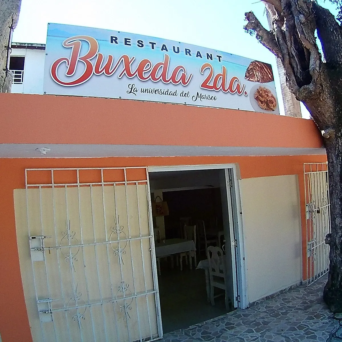 Fachada naranja de Buxeda en Boca Chica con su letrero «La universidad del Marisco»