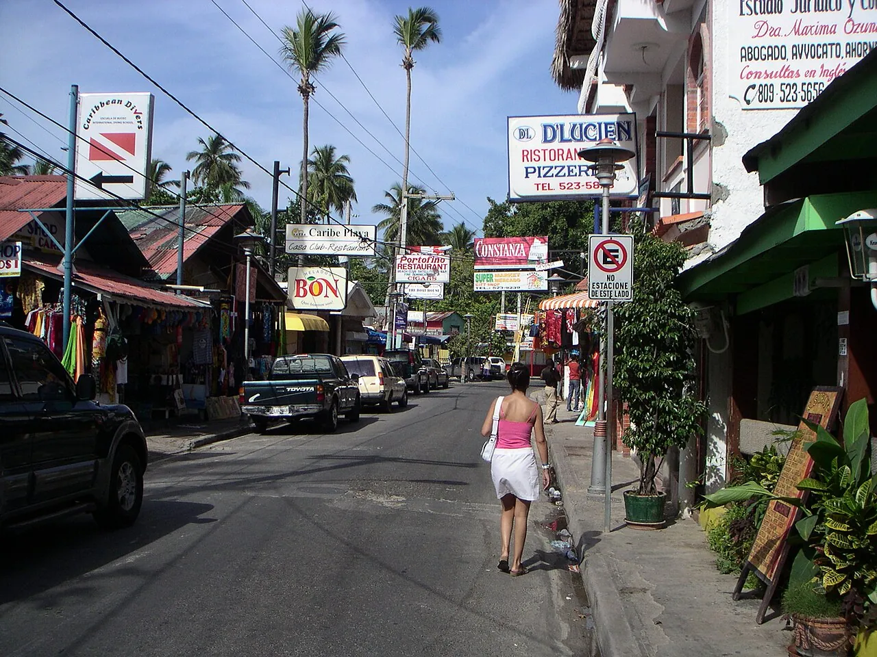 Calle de Boca Chica con letreros de una pizzería, restaurantes, una escuela de buceo y tiendas de souvenirs, en una foto de hace años
