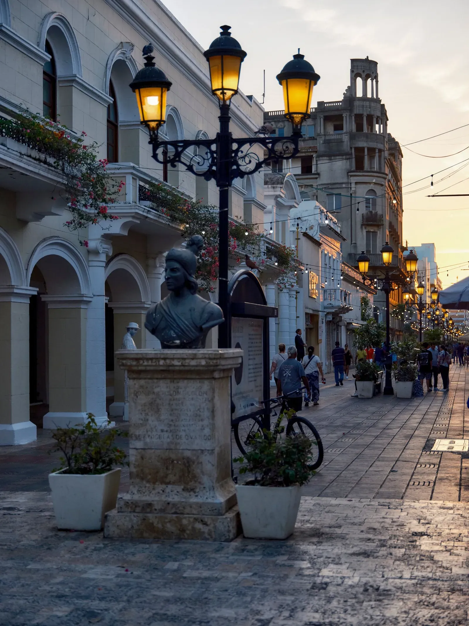 Zona Colonial Santo Domingo: Guía inmobiliaria del vibrante casco antigüo de la ciudad 5 Calle El Conde al atardecer, con sus faroles y un busto de bronce, en la Zona Colonial de Santo Domingo
