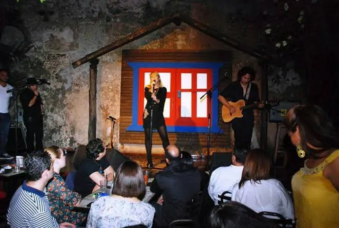 Concierto en Casa de Teatro, en la Zona Colonial de Santo Domingo, con una cantante y un guitarrista frente al público