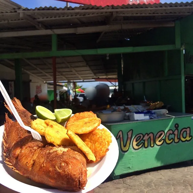 Plato de pescado frito con tostones y limón frente a la caseta Venecia en la playa de Boca Chica