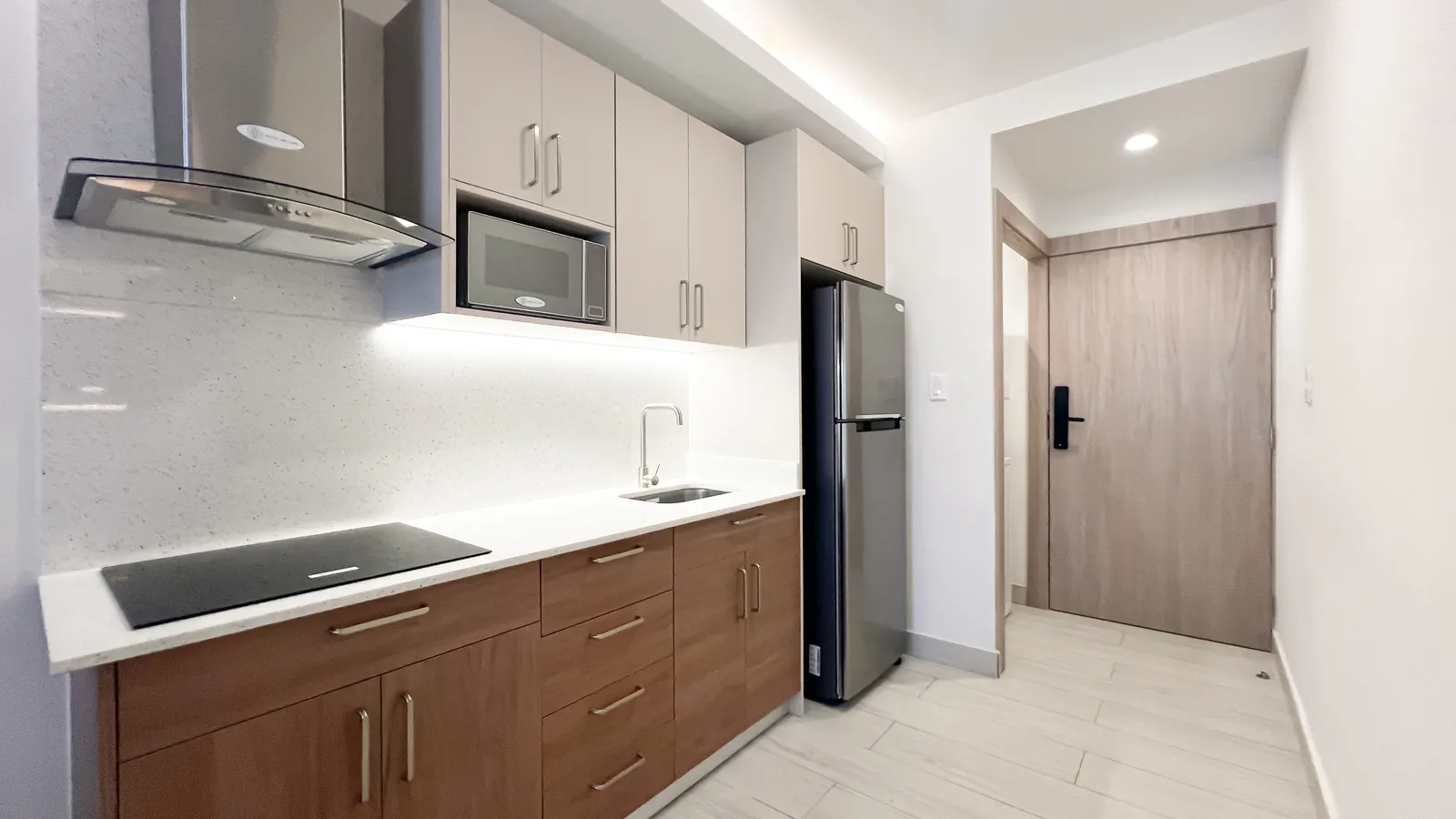 Cocina con nevera de acero y campana del apartamento modelo de Cruise On Land Punta Cana