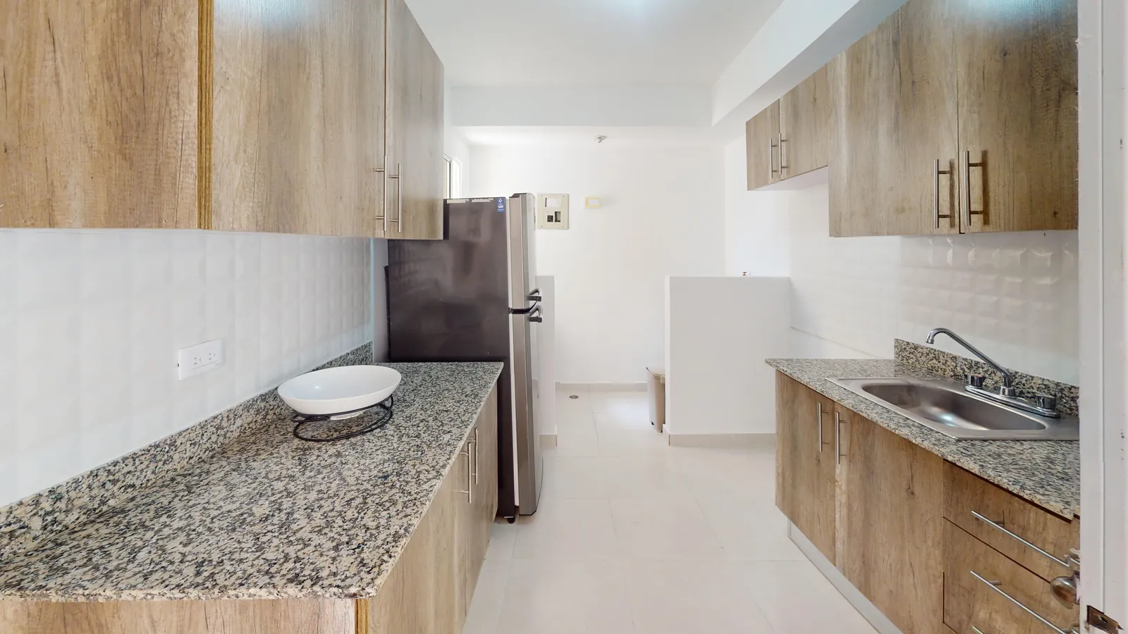 Cocina con tope de granito y gabinetes de madera del Residencial Don Galo J. Mariot