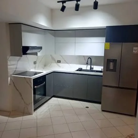 Cocina terminada con tope de mármol y nevera de acero en Civil Tower Oceance