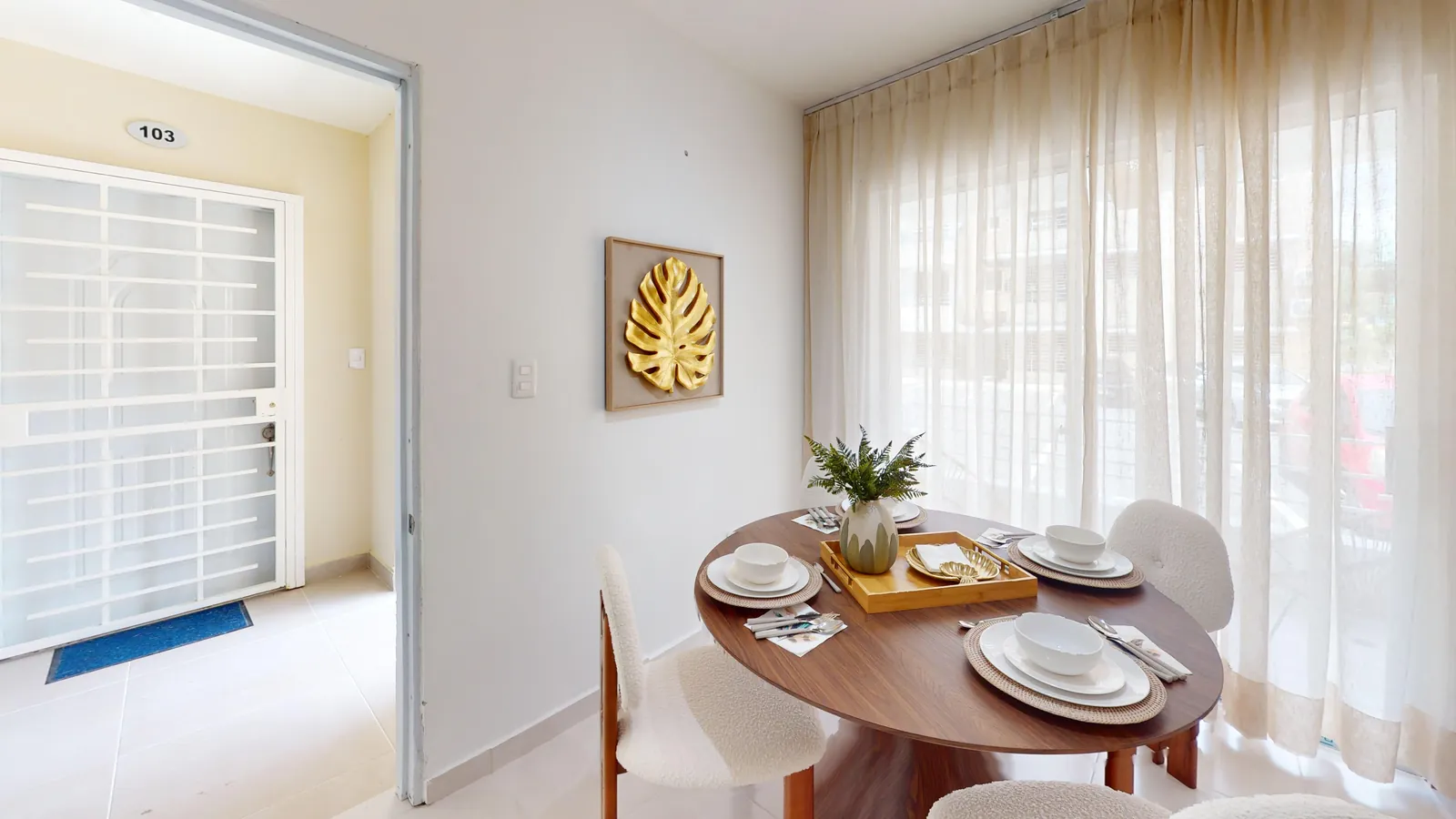 Comedor junto a la puerta del balcón en el apartamento modelo del Residencial Don Galo J. Mariot