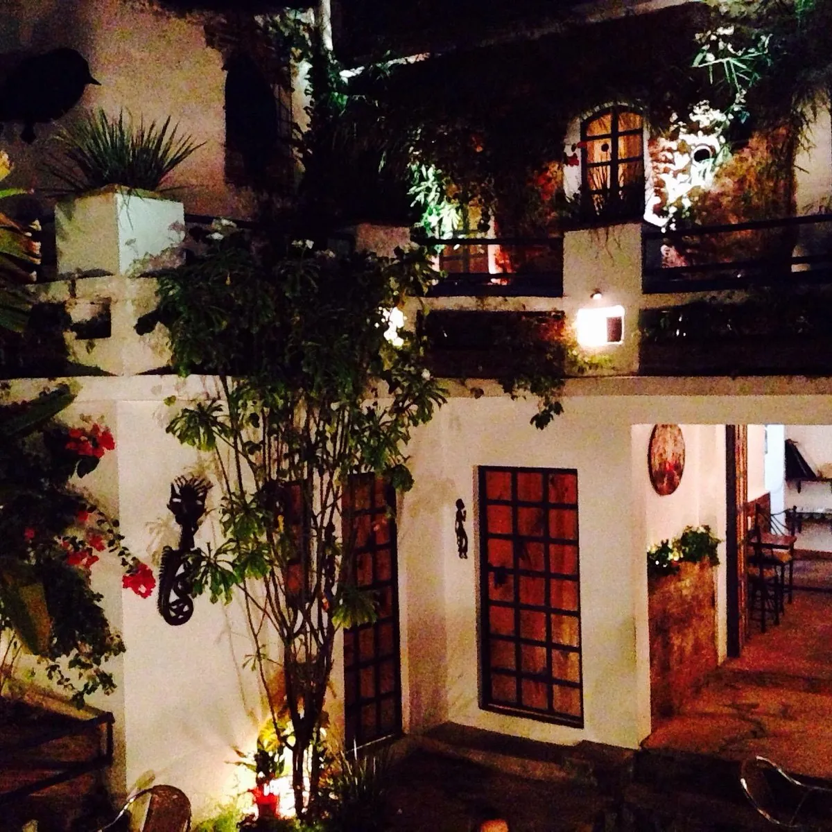 Patio de Falafel Zona Colonial de noche, en una casa colonial blanca con plantas y faroles