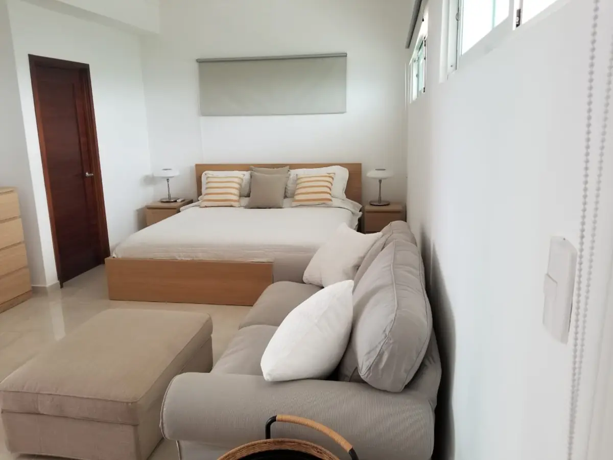 Habitación principal con cama y sofá en Tepuy Juan Dolio