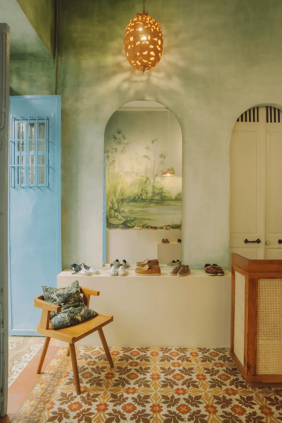 Tienda de La Alpargatería en la Zona Colonial, con alpargatas exhibidas, piso de mosaico y una lámpara de cobre