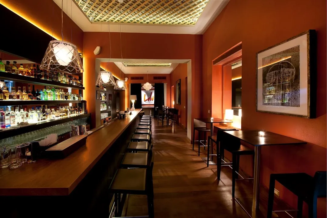 Barra interior de Lulú Tasting Bar con botellas iluminadas y paredes color terracota