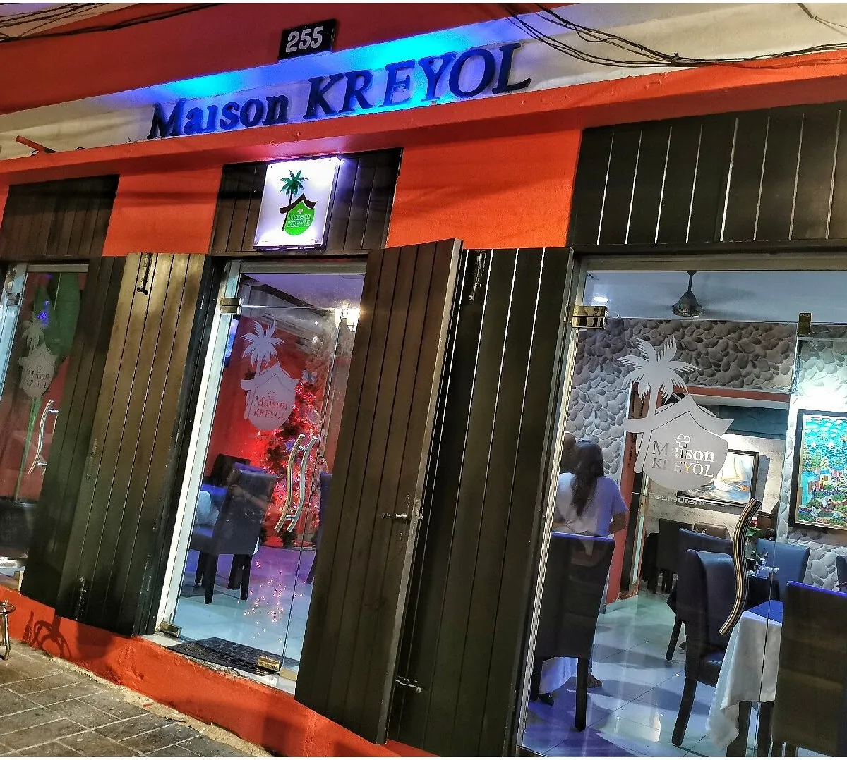 Fachada de Maison Kreyol en el número 255 de la calle Las Mercedes, con su letrero y puertas de madera