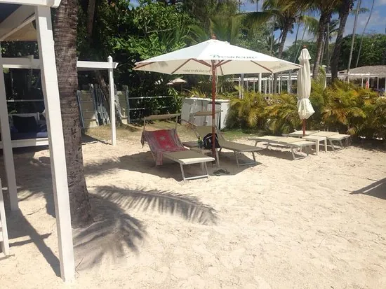 Tumbonas y sombrilla en la arena frente a Mie by Sporting Club, en la playa de Boca Chica