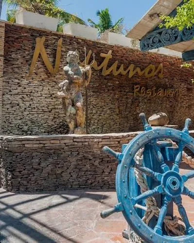 Letrero de Neptunos en Boca Chica con una estatua de Neptuno, su tridente y un timón de barco