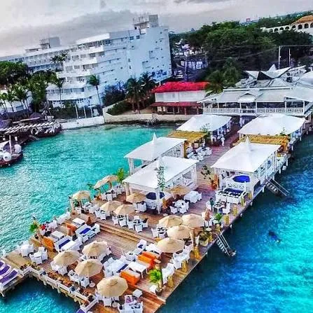 Vista aérea del muelle de Neptunos con carpas y sombrillas sobre el agua de Boca Chica