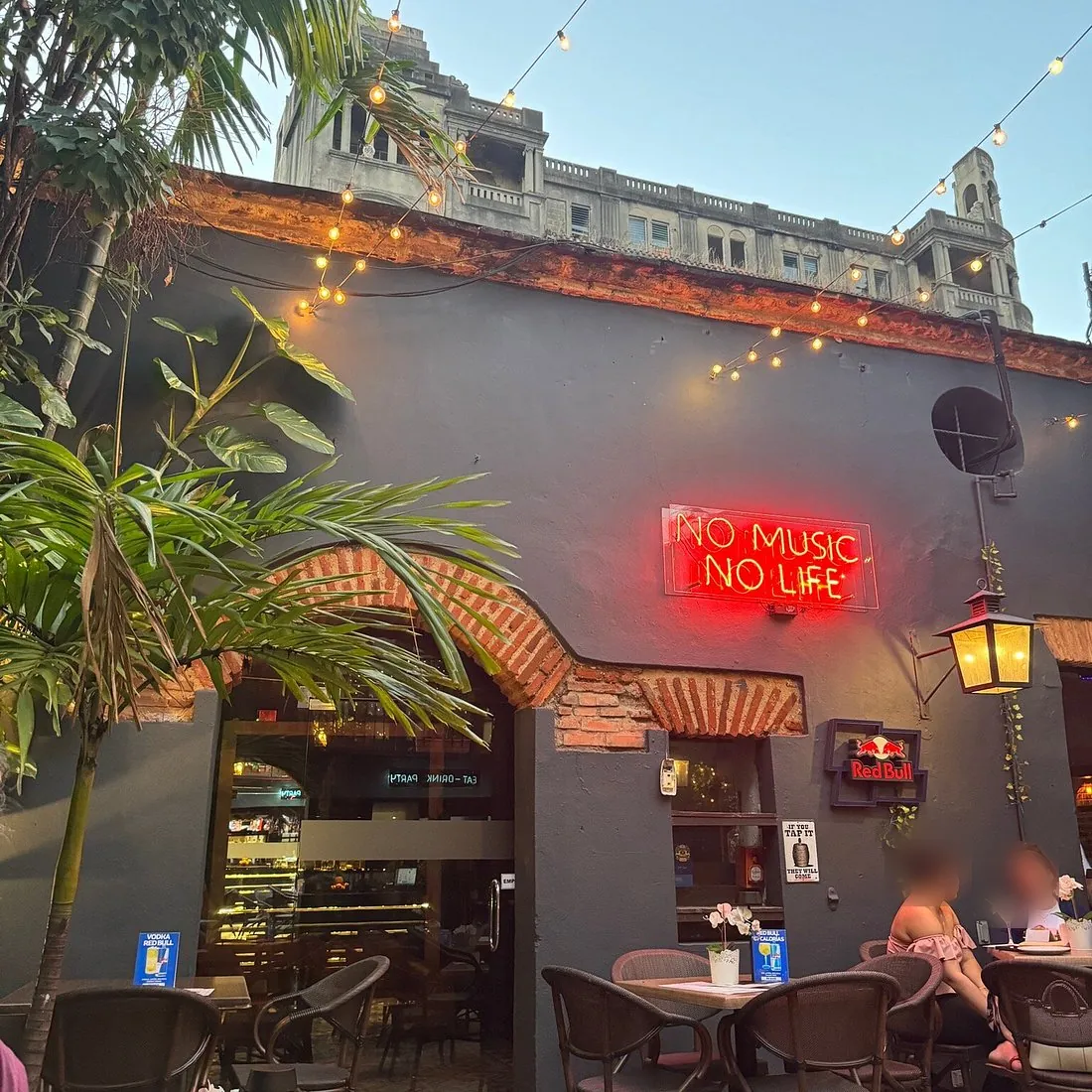 Fachada de Onno's con el letrero de neón No Music No Life y mesas en la terraza, Zona Colonial
