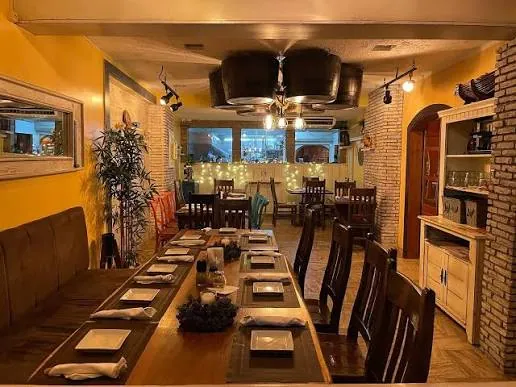 Salón de Pequeña Suiza con una mesa larga, sillas de madera y decoración rústica