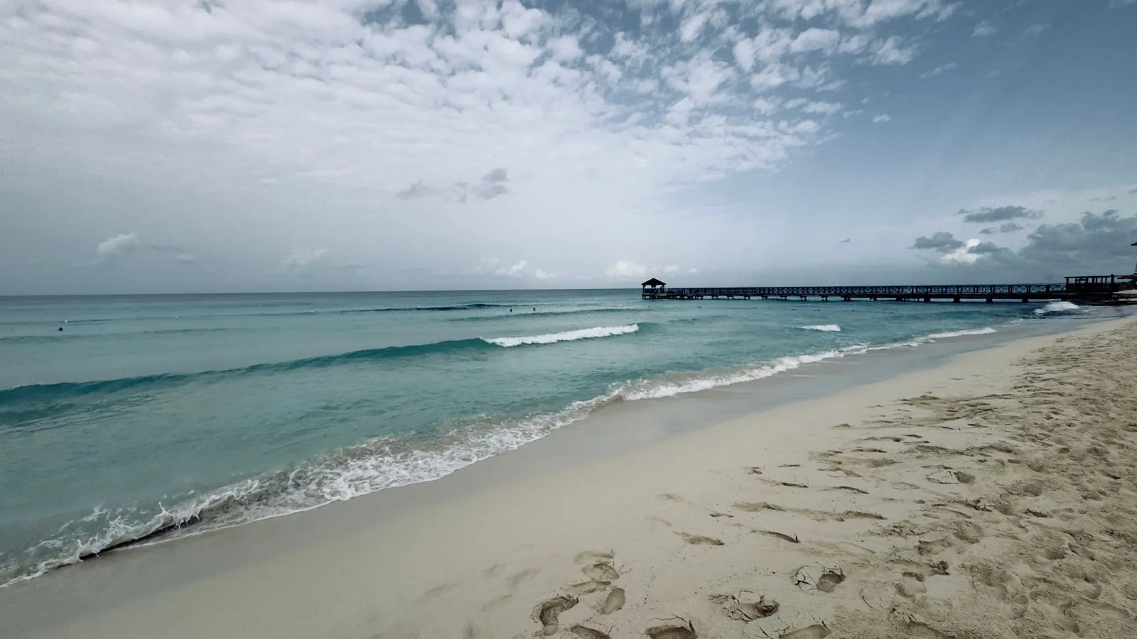 Playa de arena clara con un muelle al fondo en La Romana, República Dominicana