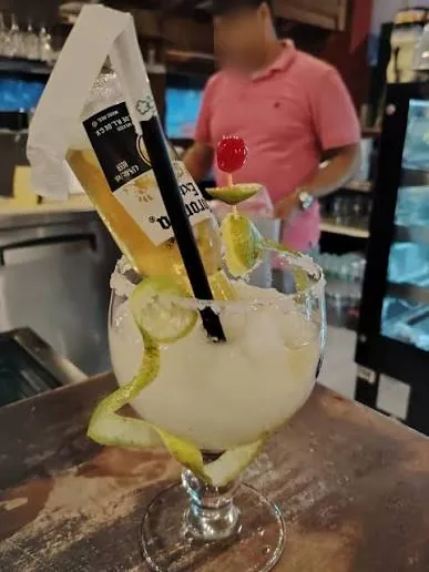 Cóctel frozen con una cerveza Corona invertida en la barra de El Puerco Rosado