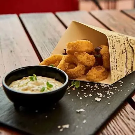 Calamares fritos en cono de papel con salsa, una de las tapas de Pura Tasca en la Zona Colonial