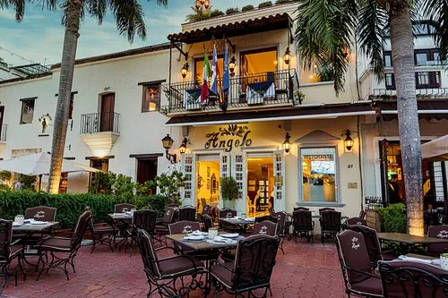 Restaurantes en la Plaza de España, frente al Alcázar | Fachada colonial del restaurante Angelo con su terraza en la calle La Atarazana, Plaza de España | Angelo, el italiano de la calle La Atarazana: una casa colonial blanca con balcones y terraza frente a la Plaza de España. | Angelo