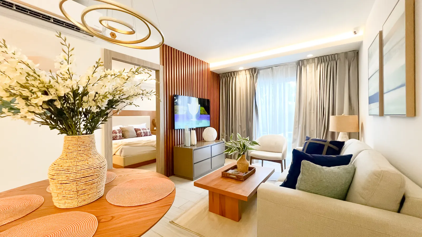 Sala del apartamento modelo de Cruise On Land Punta Cana con sofá, mesa de centro y comedor