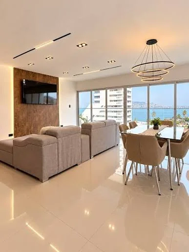 Sala y comedor con ventanales y vista al mar en un apartamento de Civil Tower Oceance